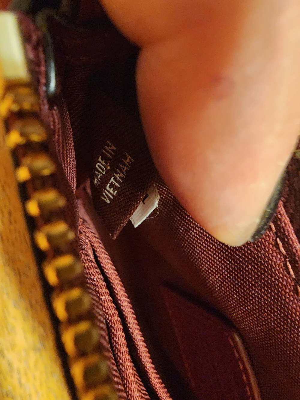 red polished pebble leather Coach wristlet, featuring gold-tone hardware